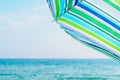 Striped beach umbrella against sea and sky background Royalty Free Stock Photo