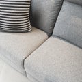 Striped cushion decorating a gray textile sofa Royalty Free Stock Photo