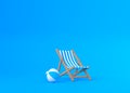 Striped deck chairs and beach ball on a blue background