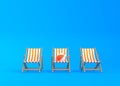 Striped deck chairs and beach ball on a blue background