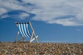 Striped deckchair on pebble beach