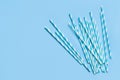 Striped and dotted paper drinking straws on light blue background Royalty Free Stock Photo