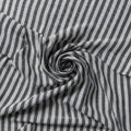 Striped fabric featuring a pattern of alternating black and white vertical lines. The fabric Royalty Free Stock Photo