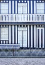 Striped facade and entrance door of a Charming typical Costa Nova house, with blue and white stripes.
