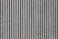 Striped gray concrete wall, with deep grooves