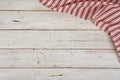 Striped kitchen napkin in the corner of wooden planks background