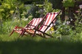 Striped lawn lounge chairs in the garden, looking forward to a vacation from work Royalty Free Stock Photo