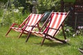 Striped lawn lounge chairs in the garden, looking forward to a vacation from work Royalty Free Stock Photo