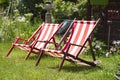 Striped lawn lounge chairs in the garden, looking forward to a vacation from work Royalty Free Stock Photo