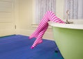 Striped legs over colorful antique bath tub