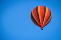 Striped multicolored balloon in a bright blue summer sky