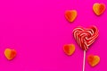 Striped screwed red and white heart-shaped candy on a stick and marmalade in sugar on a pink background. Sweet treat. Royalty Free Stock Photo