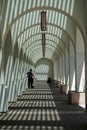 Striped shadow from the arch roof of the building on the ground and two people talking