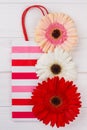Striped shipping bag and flowers on white background.