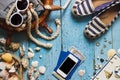 Striped slippers, phone and maritime decorations on the wooden b