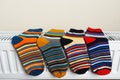 Striped socks are being dry on the radiator Royalty Free Stock Photo