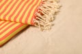 Striped soft beach towel on sand, closeup