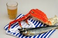 The striped vest. Kamchatka king crab and dried fish on it. Glass of beer