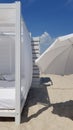 Striped wood wall with white sunshade and white textile parasol