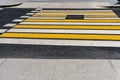 Striped yellow and white pedestrian zebra crossing on gray asphalt, abstract background. Crosswalk on the road for people`s safet Royalty Free Stock Photo