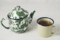 Stripes vitreous enamel teapot and tea cups with tea