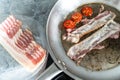 Bacon strips and cherry tomatoes are fried in a stainless steel pan. Royalty Free Stock Photo