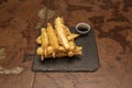 Strips of battered eggplant fried in tempura accompanied by a container with sugar cane honey Royalty Free Stock Photo