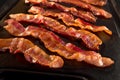 Strips of crispy bacon on cast iron pan