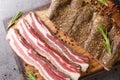 Stripy cured pork side bacon pancetta smoked on wood chip closeup on the wooden board. Horizontal top view