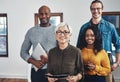 We strive to be the best we can. Portrait of a group of confident businesspeople seated together inside of the office Royalty Free Stock Photo