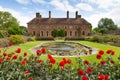 Strode House Barrington Court near Ilminster Somerset England uk with Lily pond garden and red dahlias in summer