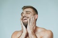 He stroked and touched his beard. A beautiful beard. Beautiful sporty guy male power. Fitness muscled in blue shorts. Royalty Free Stock Photo