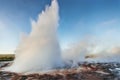 Strokkur geyser eruption in Iceland. Fantastic colors shine through the steam. Beautiful pink clouds in a blue sky Royalty Free Stock Photo