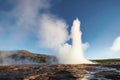 Strokkur geyser eruption in Iceland. Fantastic colors shine through the steam. Beautiful pink clouds in a blue sky Royalty Free Stock Photo