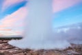 Strokkur geyser eruption in Iceland. Fantastic colors shine through the steam. Beautiful pink clouds in a blue sky Royalty Free Stock Photo