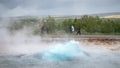 The Strokkur geyser erupts while tourists are wondering in the geothermal area, Iceland Royalty Free Stock Photo