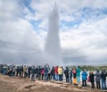 The Strokkur geyser in Iceland is erupting while tourists are watching Royalty Free Stock Photo