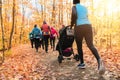 Stroller woman group out running together in an autumn park they run a race or train in a healthy outdoors lifestyle