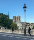 Strollers on Paris bridge looking at towers of Notre Dame Royalty Free Stock Photo