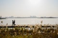 Strollers walking on lakeside planked path in sunny winter after