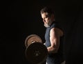 Strong, active, middle aged man with gray beard lifting heavy weights in studio setting