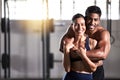 Strong, active and wellness couple looking fit and healthy after workout training session in a gym. Young sexy