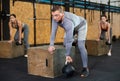 Strong adult man doing jumping exercises over box at cross training style gym. Fit sportsman jump at box in workout gym Royalty Free Stock Photo