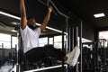 Strong african man doing statics exercise on horizontal bar, having workout at gym. Royalty Free Stock Photo