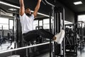 Strong african man doing statics exercise on horizontal bar, having workout at gym. Royalty Free Stock Photo