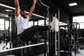 Strong african man doing statics exercise on horizontal bar, having workout at gym. Royalty Free Stock Photo