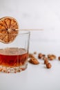 Strong alcohol whisky in a glass cup with a slice of dried orange and nuts Royalty Free Stock Photo