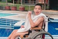 Strong arm muscles of Asian special child on wheelchair with swimming pool Royalty Free Stock Photo