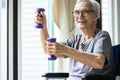 Strong asian senior woman working out with heavy dumbbells,lifting dumbbell weights for strength training,fitness elderly people Royalty Free Stock Photo