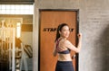 Strong asian woman posture standing and lifting up her arms and exercises muscle at gym